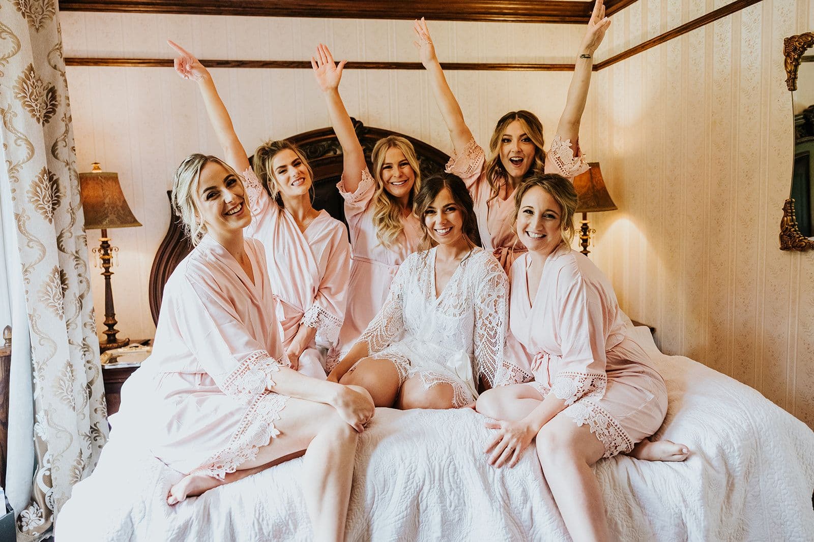 Erin Estates, Wedding Venue, Fedora Media, Cambridge Wedding Photographer, Bride & Bridesmaids sitting on bed in robes cheering