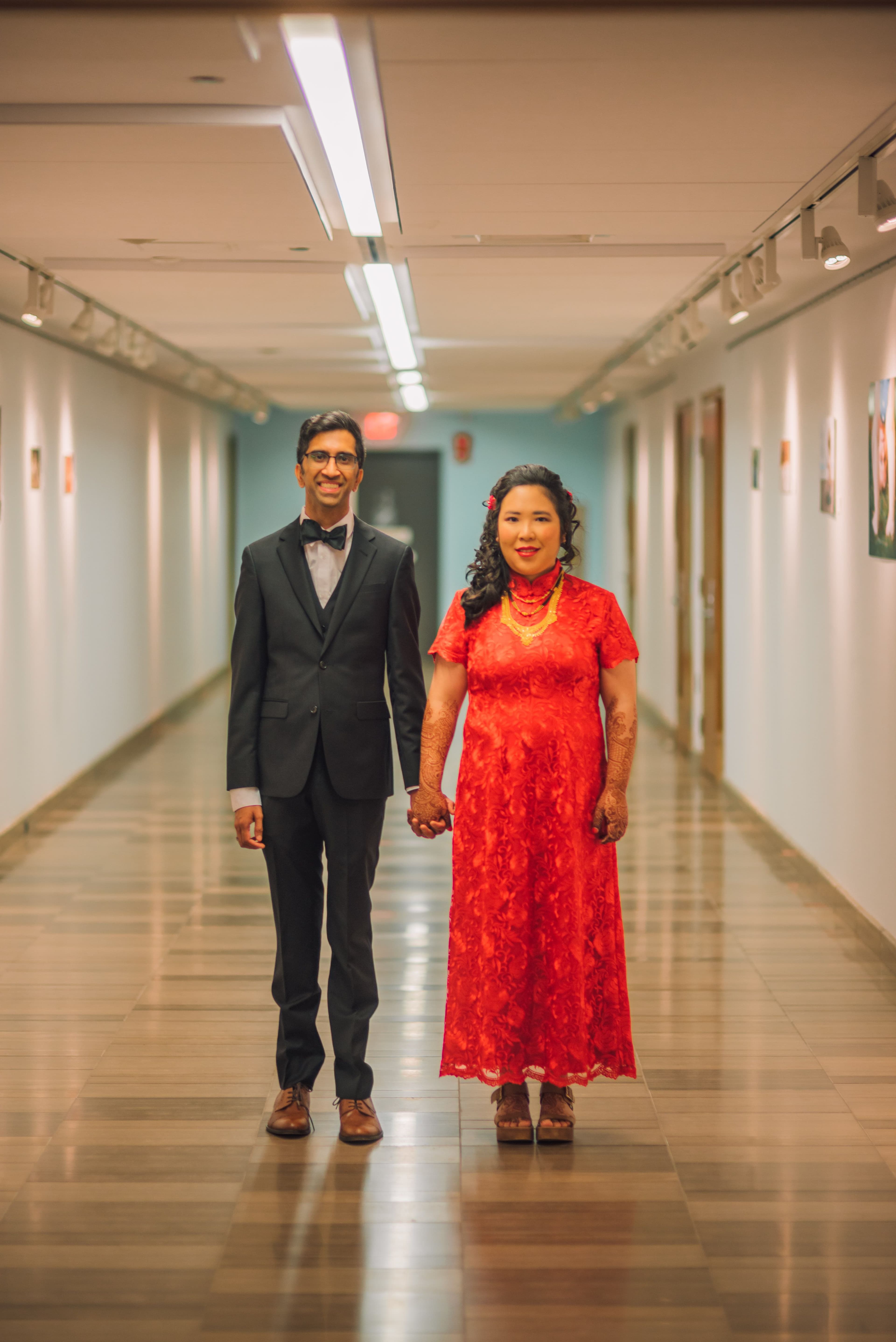 The Wedding Ring, Kitchener Public Library, Peter B Photography, KW wedding photographer, Kitchener wedding venue, Waterloo wedding venue, Cambridge wedding venue, bride and groom holding hands in hallway. bride in red dress, groom in black tux