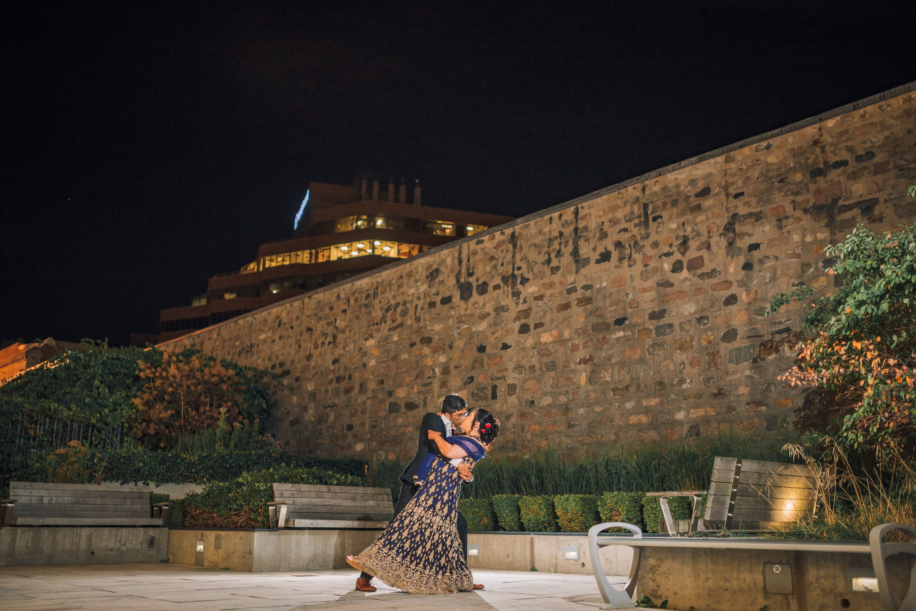The Wedding Ring, Kitchener Public Library, Peter B Photography, KW wedding photographer, Kitchener wedding venue, Waterloo wedding venue, Cambridge wedding venue, bride and groom kissing in front of stone wall at night