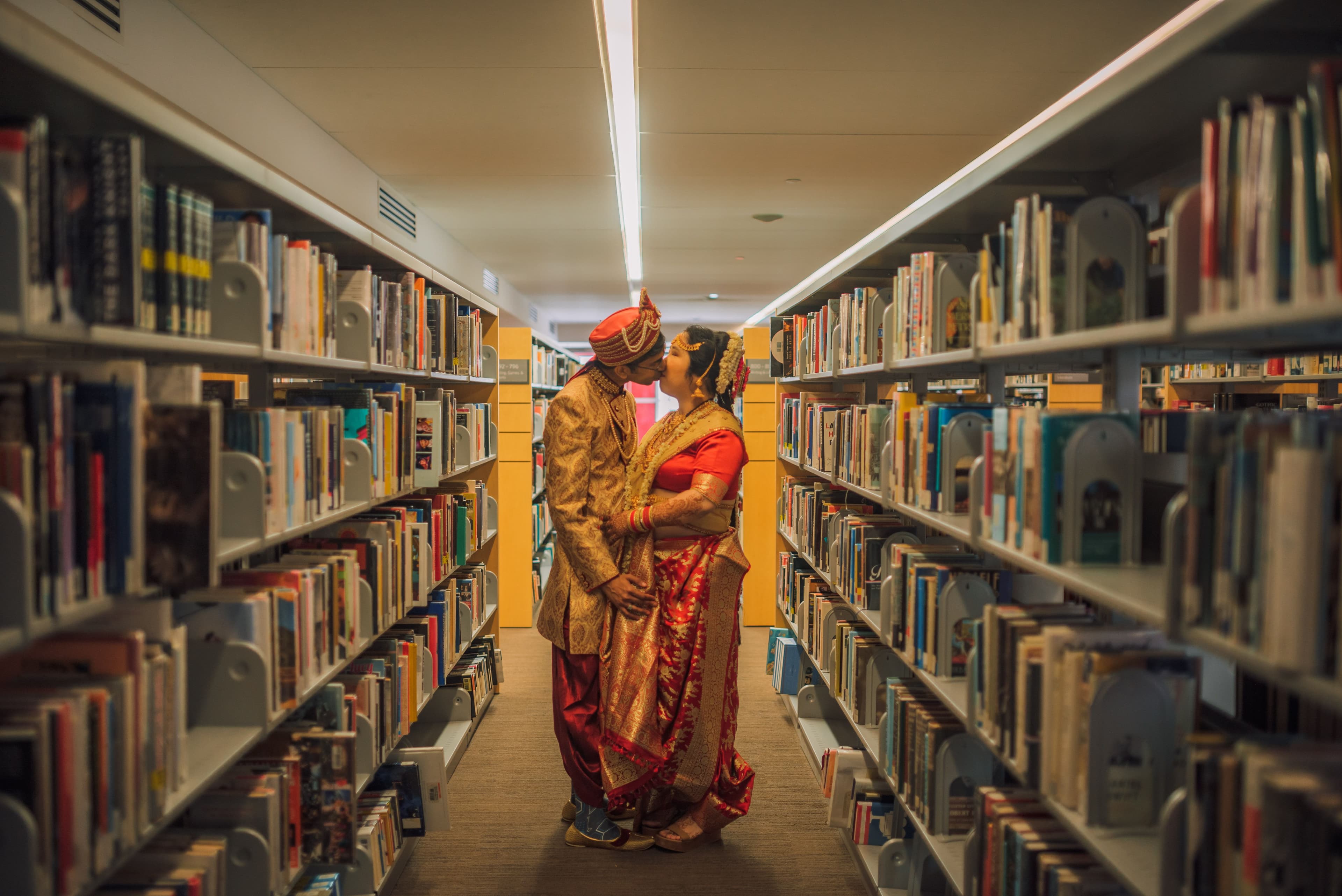 The Wedding Ring, Kitchener Public Library, Peter B Photography, KW wedding photographer, Kitchener wedding venue, Waterloo wedding venue, Cambridge wedding venue, bride and groom kissing in aisle at library surrounded by books